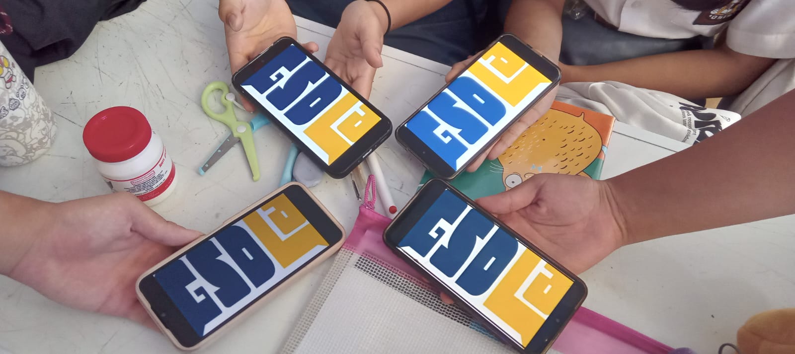 Students holding phones showing the GSDLA logo